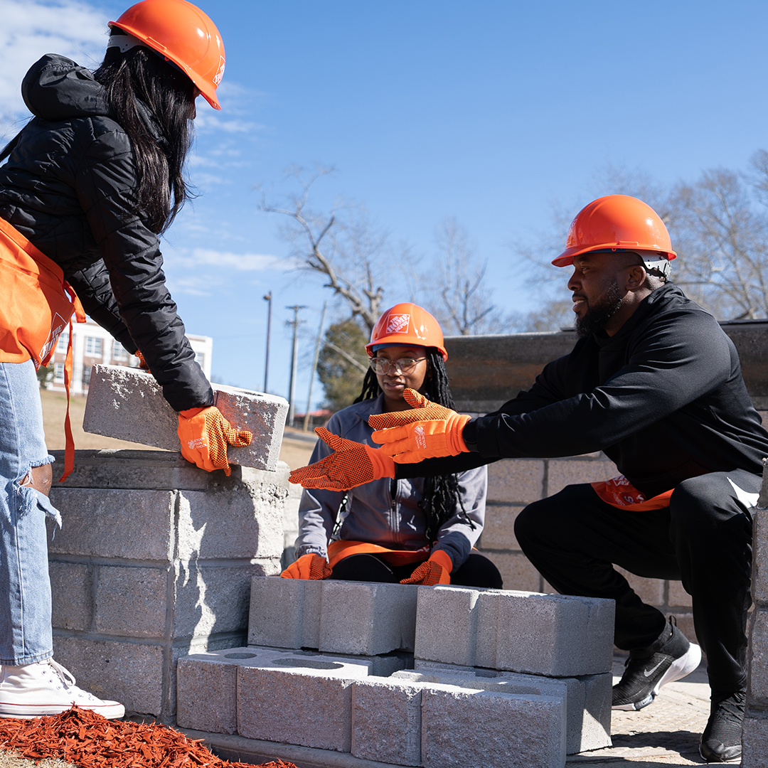 People stacking bricks